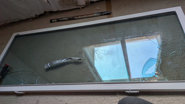 Broken glass in the original basement window before replacement.