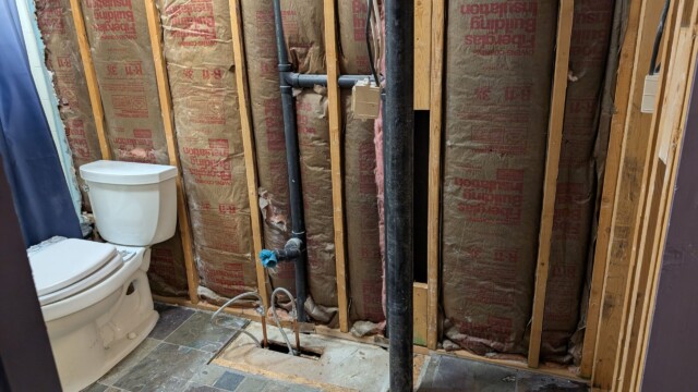 Exposed framing and plumbing at the start of the bathroom remodel.