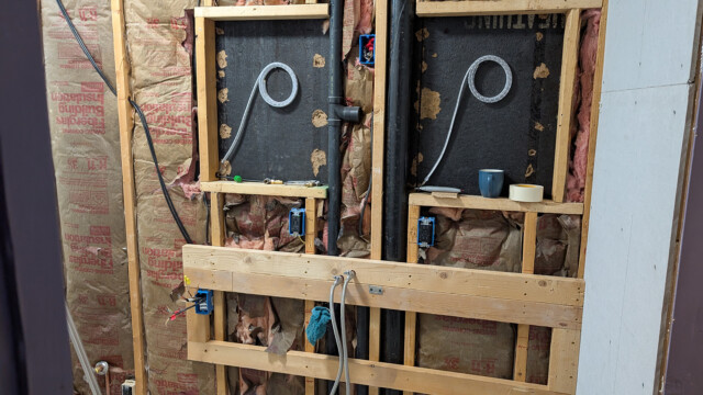 Shower framing and plumbing before wall installation.