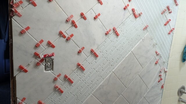 Wall tile being set with spacers in place.